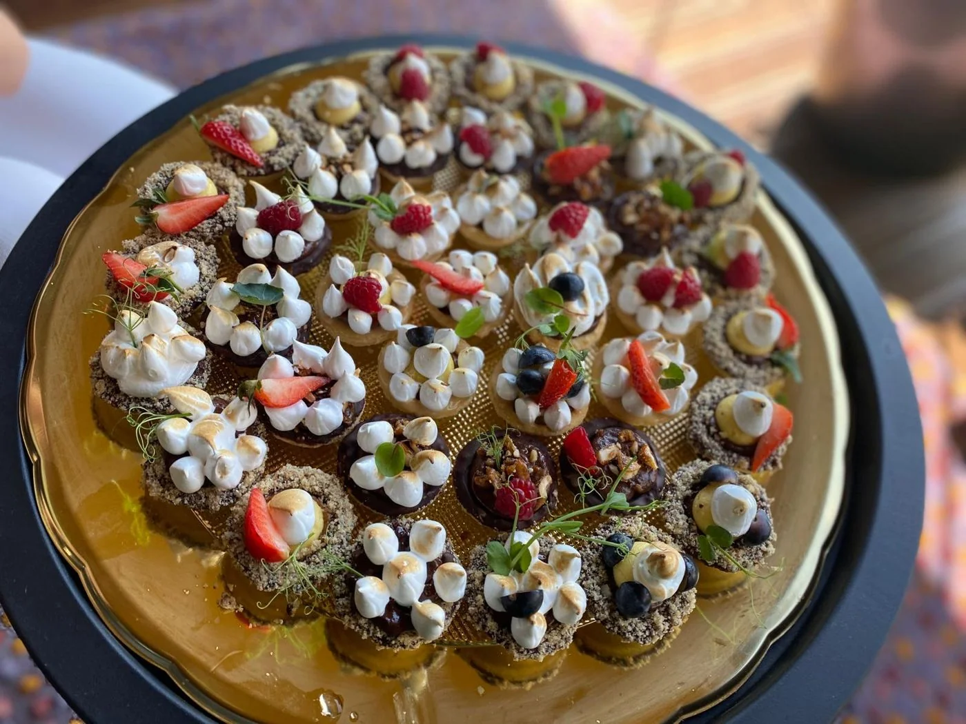 Platte mit Mini-Baiser-Tartelettes, Erdbeeren und Himbeeren